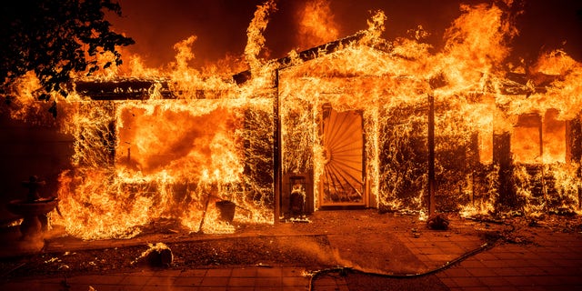 Flames consume a home on Triangle Rd. as the Oak Fire burns in Mariposa County, Calif., on Saturday, July 23, 2022.